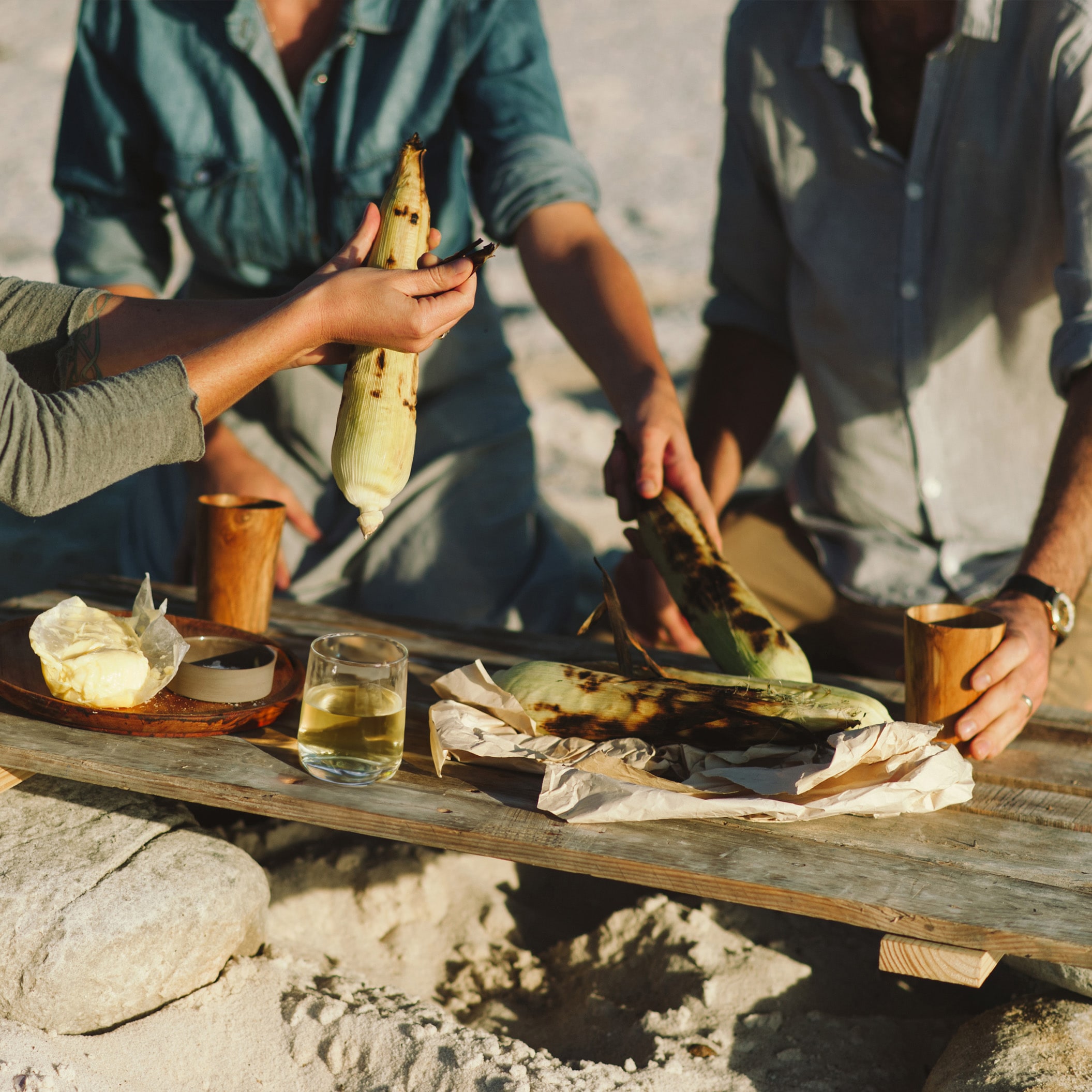 People cooking corn at the beach